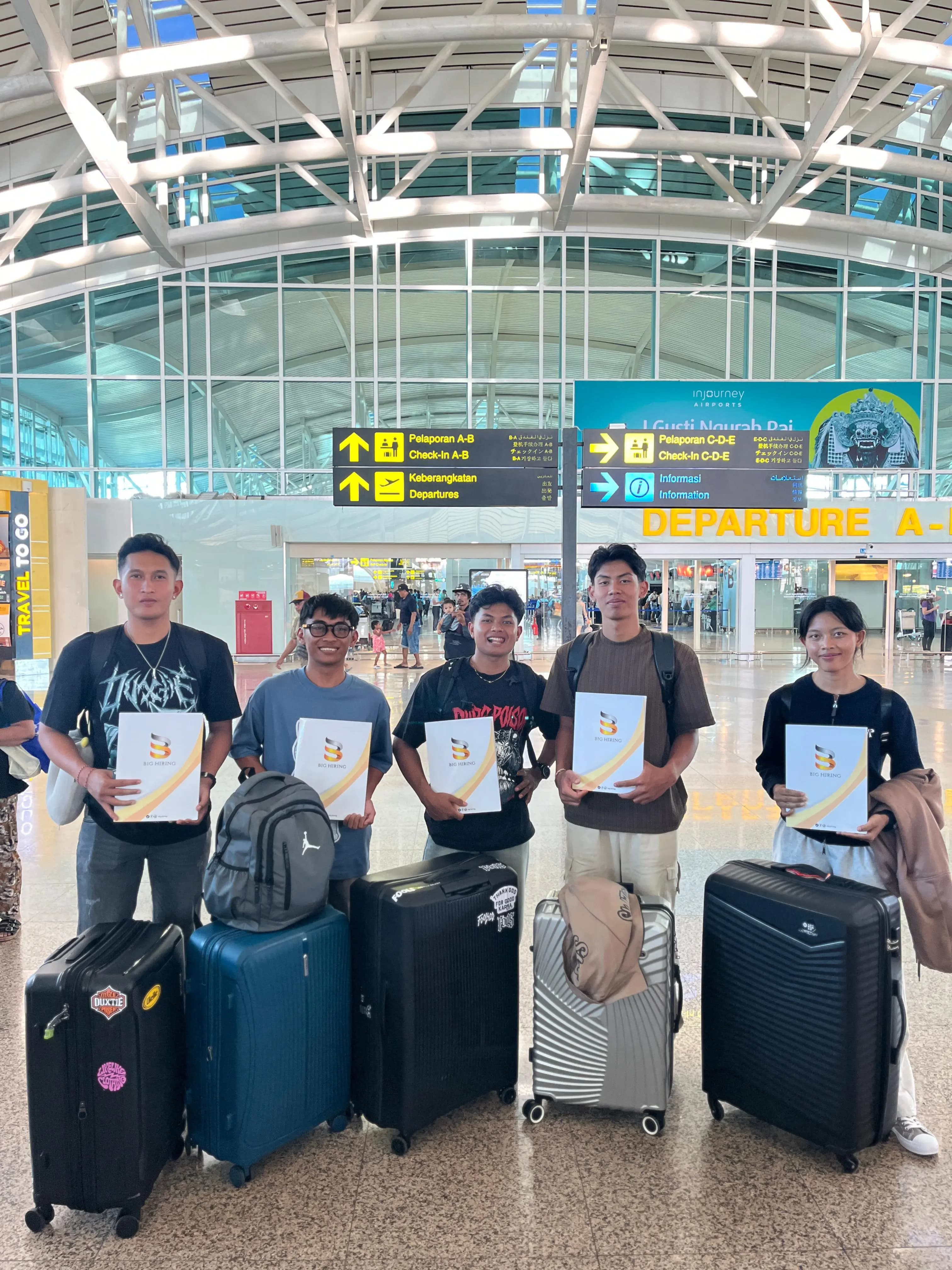 Big Hiring candidates holding placement documents at an airport