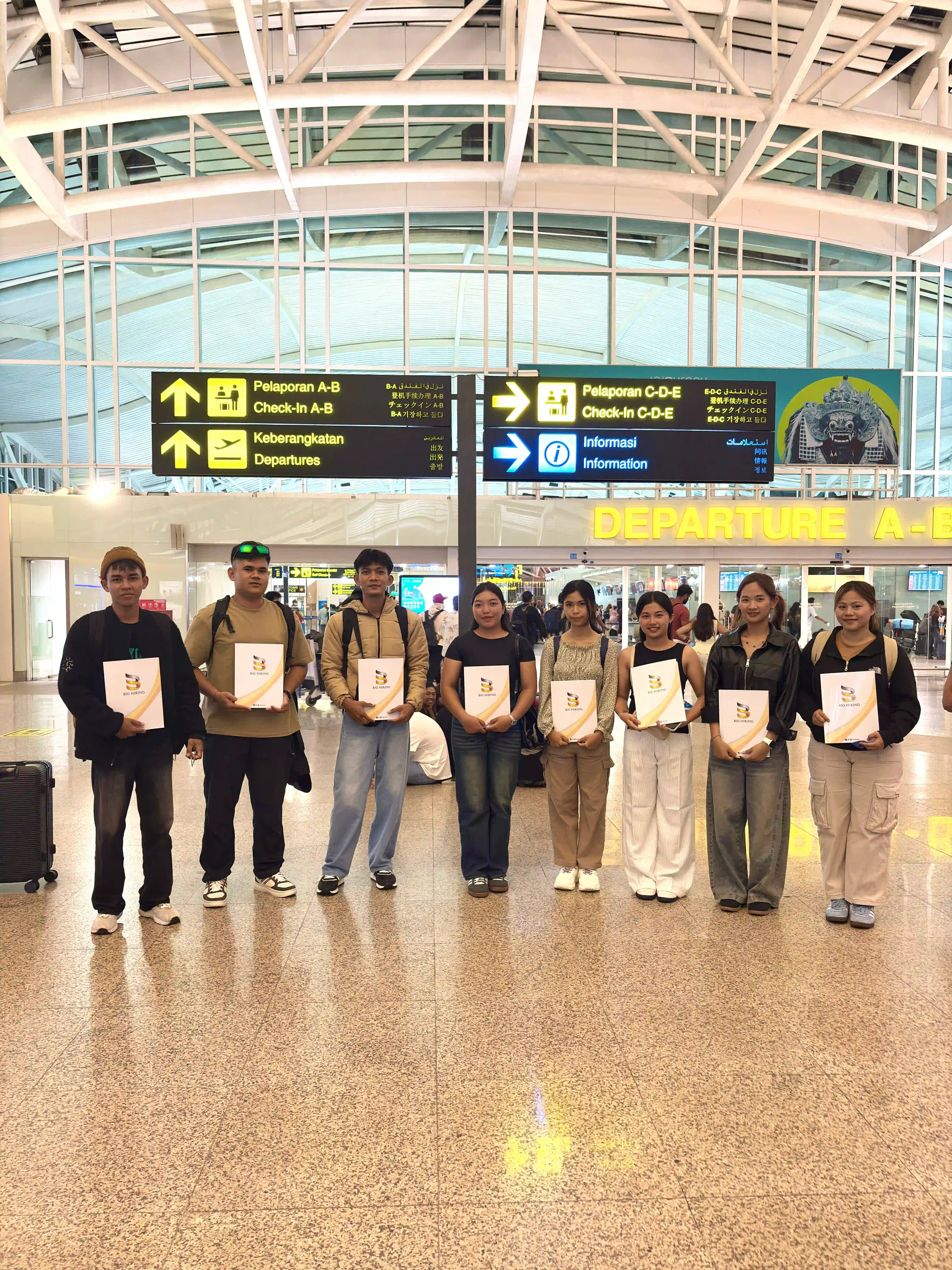 Big Hiring candidates holding placement certificates at an airport